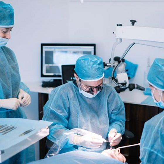 Dental team carefully working on patient’s mouth during surgery