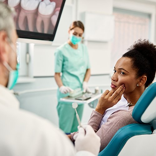 Woman in the dental chair with tooth pain